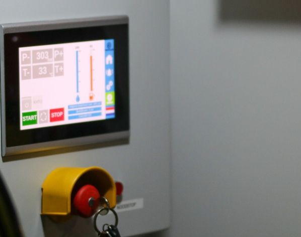Industrial control panel with a human-machine interface and emergency stop.